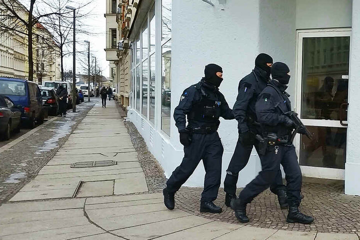 Vermummte Polizisten patroullieren auf der Eisenbahnstraße - zur Absicherung einer Razzia.