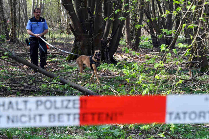Ein Polizeibeamter mit Hund auf der Suche nach Spuren der vermissten Georgine Krüger im April 2018.