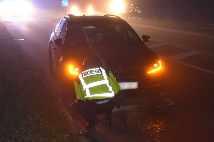 Ein Polizeibeamter am Skoda des Unfallverursachers.