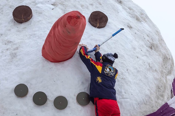 Mitglieder des Skiklub Carlsfeld schnitzen am neuen Riesen-Schneemann.
