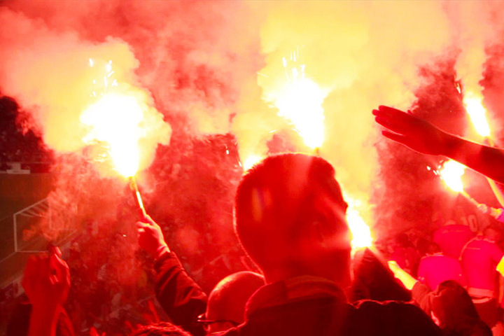 Einige Galatasaray-Anhänger zünden im Stadion bengalische Fackeln.