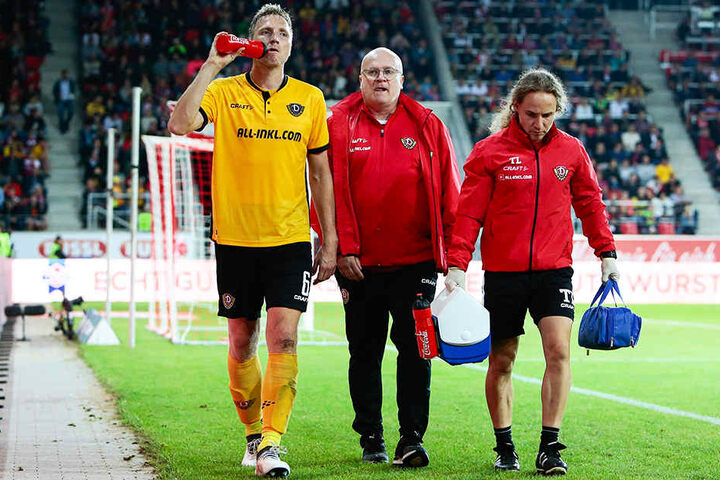 v.l.: Dynamos Kapitän Marco Hartmann wird nach seiner Auswechslung vom Mannschaftsarzt Dr. Tino Lorenz und Physio Tobias Lange begleitet.