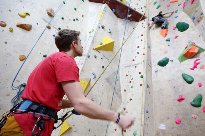 Ein Mann sichert seine Kletterpartnerin mit einem Seil - beim Bouldern wird ohne Absicherung geklettert.