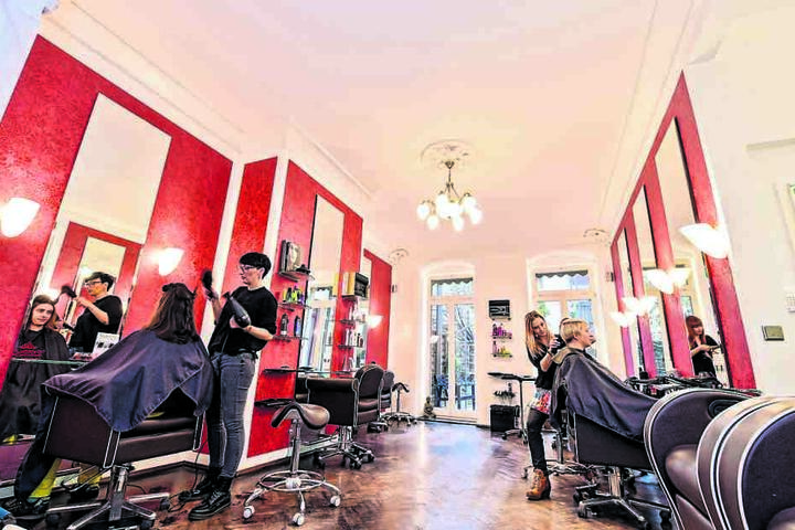 Nach zehn Tagen Frischekur strahlt der Salon in hellem Weiß und rotem Tapetenmuster.