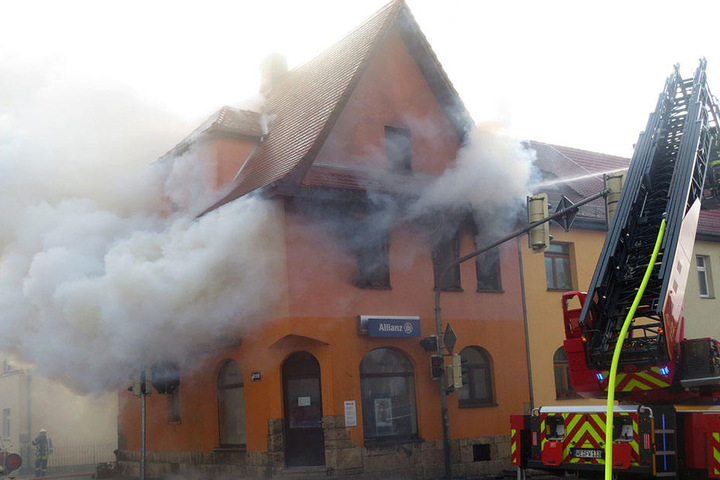Die Feuerwehr löscht einen Hausbrand in Weimar (Thüringen). Flammen und dichte Rauchwolken schlagen aus den Fenstern des Eckhauses am Weimarer Stadtring.