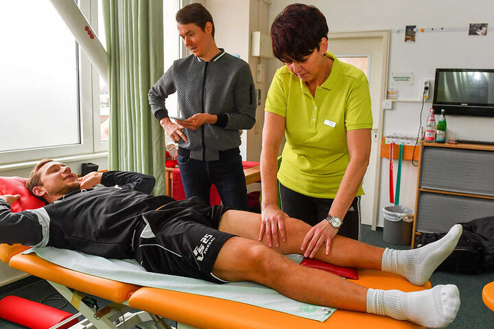 Physiotherapeutin Heike Noack tastet das verletzte linke Knie ab, Robert Koch beantwortet derweil die Fragen von TAG24-Reporter Michael Thiele.