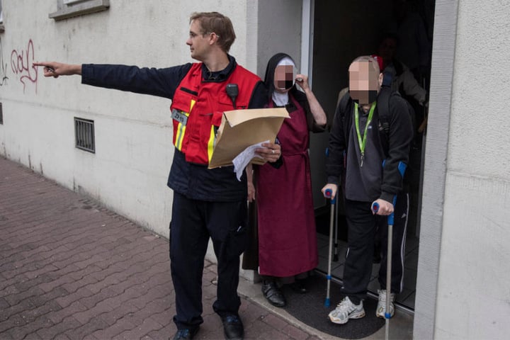 Ein Mitarbeiter der Feuerwehr koordiniert die Evakuierung von gehbehinderten Menschen in Frankfurt.