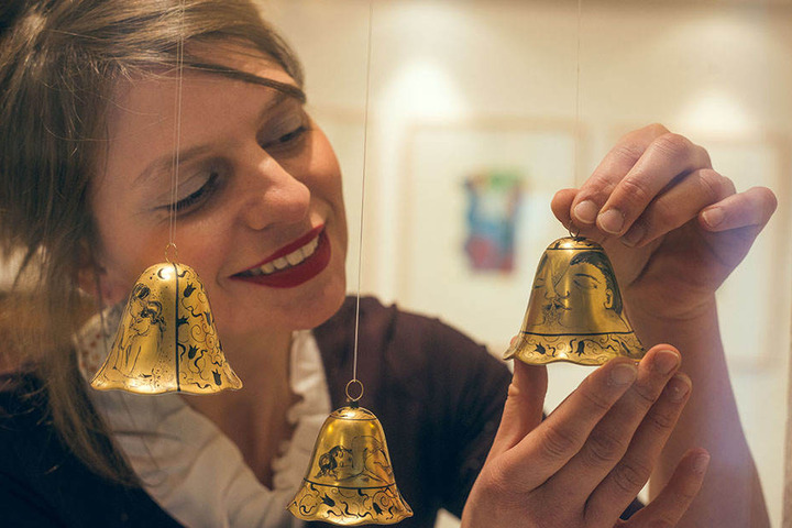 Hier hält Janett Noack ein Glöckchen mit aufgemalter Kussszene.