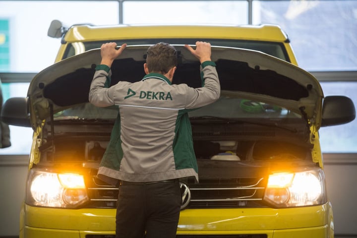 Ein Mitarbeiter der Prüforganisation Dekra öffnet im Rahmen einer Hautuntersuchung (HU) die Motorhaube eines VW T5 Diesel. (Symbolbild)