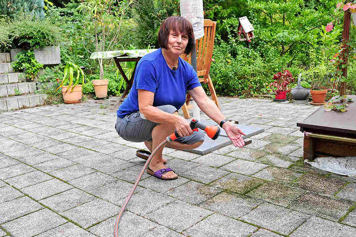 Mit dem Gartenschlauch bekommt Margitta Ost (67) die schwarzen Flecken auf
der Terrasse nicht weg. Die Anwohnerin braucht Hochdruckreiniger.