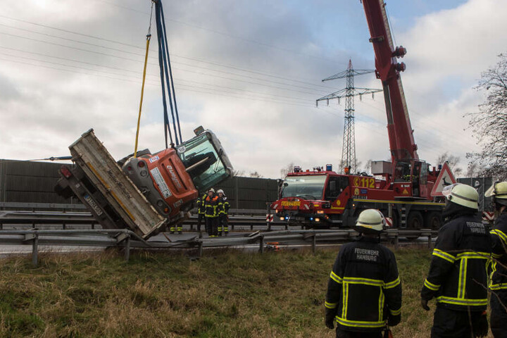 Mit einem Kran wird der Bagger wieder in eine aufrechte Position gehievt.