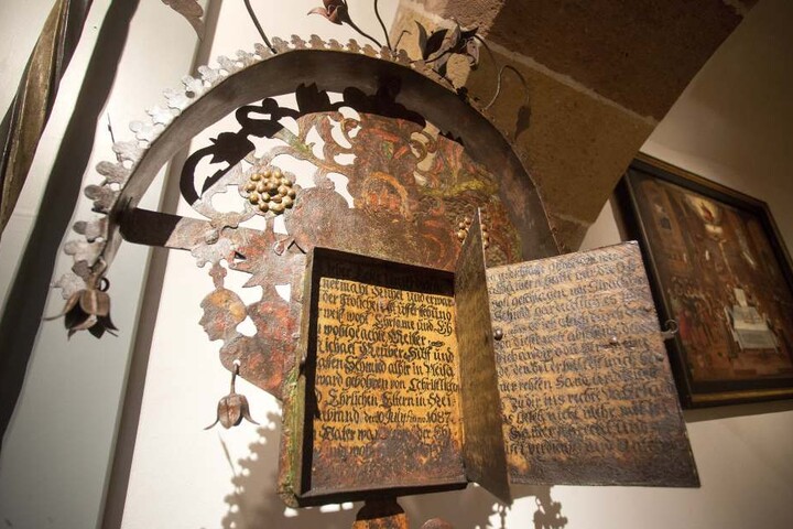 Eine Art Buch am schmiedeeisernen Grabkreuz erzählt vom Leben des
Verstorbenen. Eines von 70 Ausstellungsstücken.