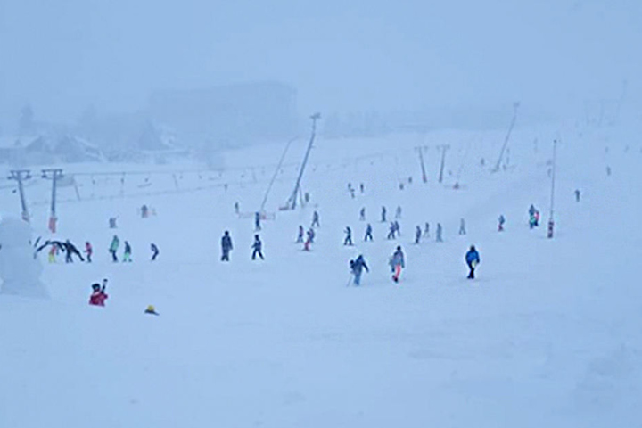 Trotz des Wetters sind einige Skifahrer auf dem Fichtelberg unterwegs.