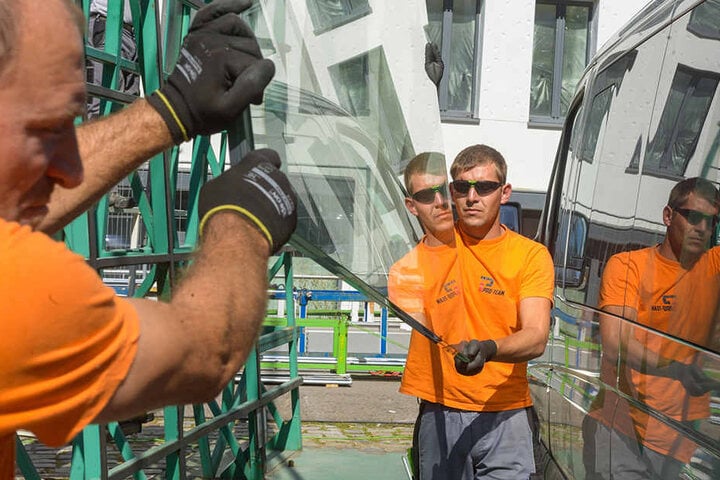 Die Arbeiter mit einer der schweren Glasscheiben.