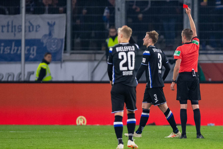 Schiedsrichter Michael Bacher zeigt Bielefelds Brian Behrendt (M) die Rote Karte.