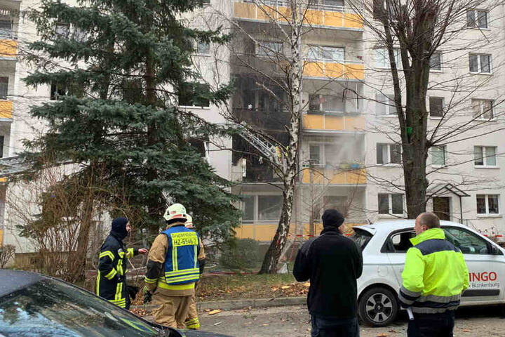 Die Feuerwehr löscht Brandreste am Mehrfamilienhaus ab.