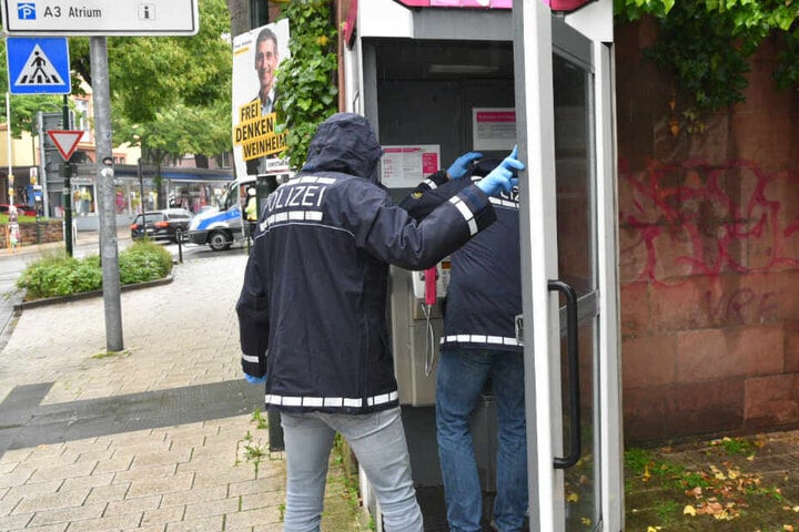 Von dieser Telefonzelle kam wohl der Notruf. Im Bild: die Spurensicherung.