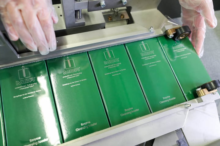 Eine Mitarbeiterin der Medical Beauty Research GmbH (MBR) verpackt Kosmetikartikel aus der "The Best"-Kollektion.