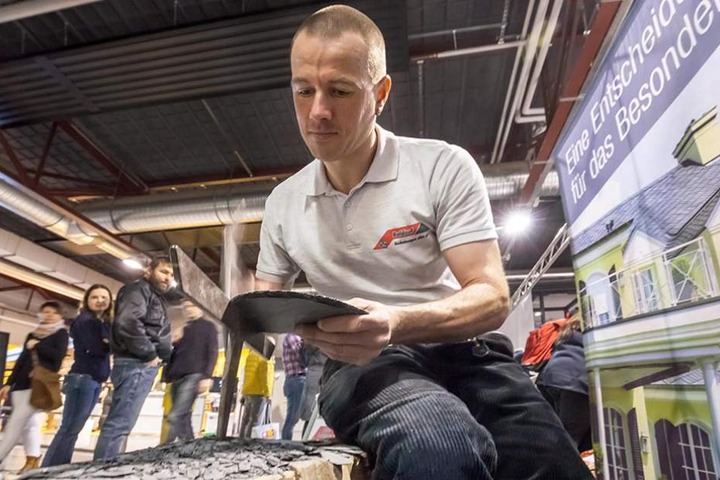Dachdecker Daniel Fischer (40) zeigt auf der Baumesse seine
Handwerkskunst.