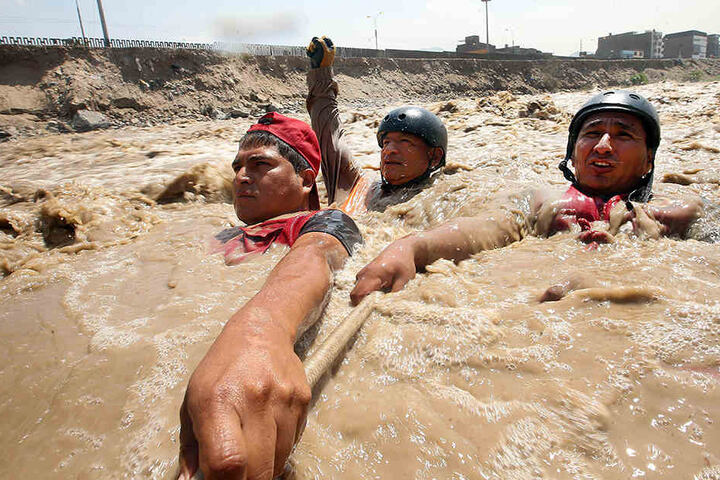 Reservisten der peruanischen Armee und bei Rettungsarbeiten in einem überschwemmten Fluss.