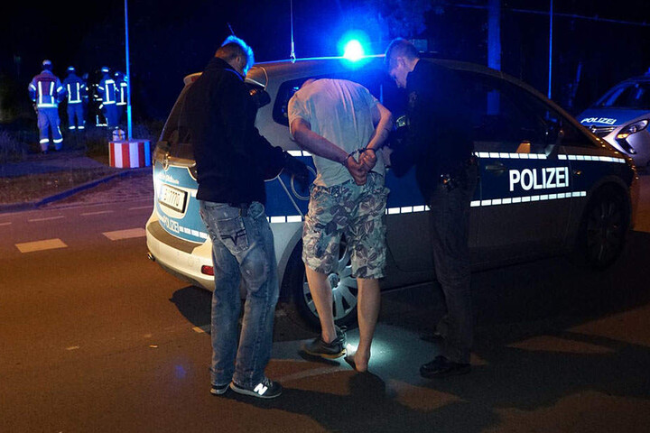 Der per Haftbefehl gesuchte Fahrer wird von den Polizeibeamten abgeführt.