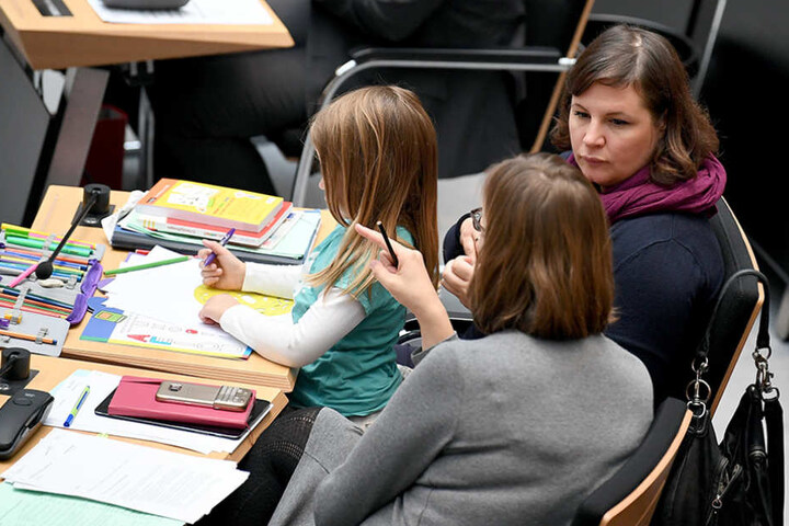 Neben Mutter und Kind sitzt die Abgeordnete Silke Gebel (Bündnis 90/Die Grünen, vorne).