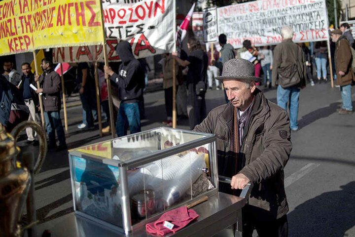 Ein Straßenverkäufer bietet am Rande einer Demonstration gegen die Armut in Griechenland Getränke an.