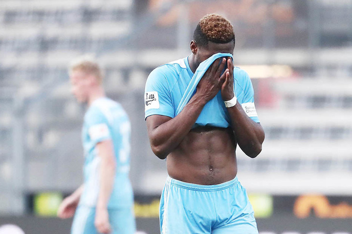 Emmanuel Mbende vergräbt enttäuscht sein Gesicht ins himmelblaue Trikot.