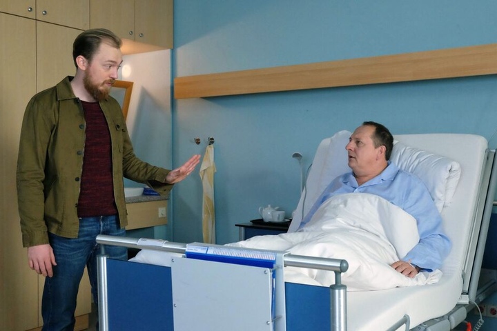 Robert Hubmann (Tino Mewes, li.) fordert von Dieter Kovalsky (Thomas Kügel, re.) eine Erklärung: Warum hat er ein Foto von Roberts Mutter und ihm als Baby in seiner Geldbörse?