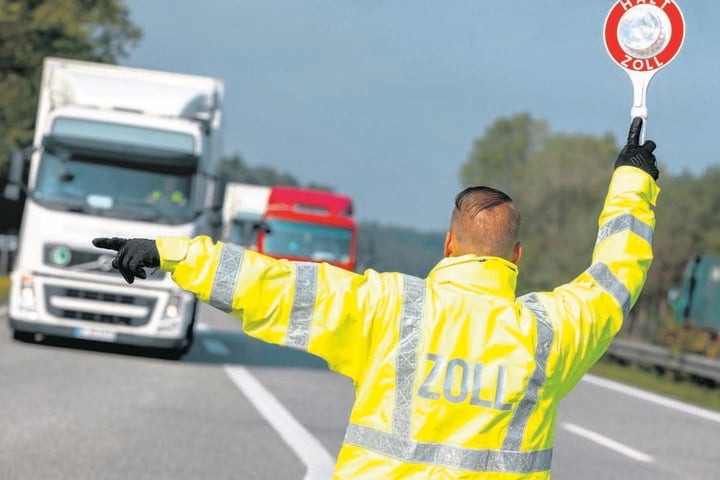 Ein Zöllner lotst einen Lkw von der Autobahn zur Kontrollstelle. Ein Großteil des illegal eingeführten Tabaks wurde in Lastwagen entdeckt.