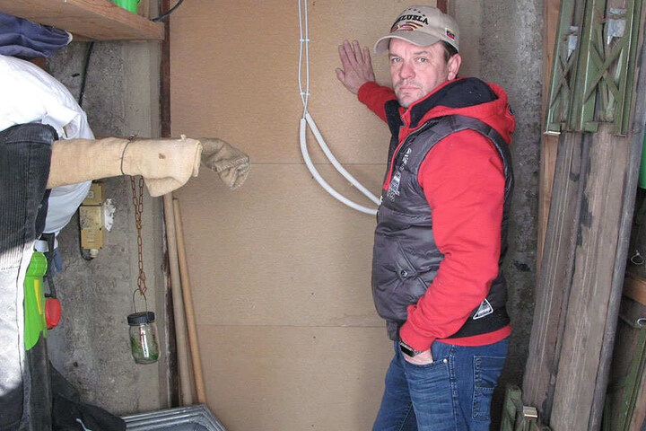 An dieser Wand scheiterte der Einbrecher: Mario Wiegner zeigt die stabile
Spanholzplatte hinter dem Hintereingang.