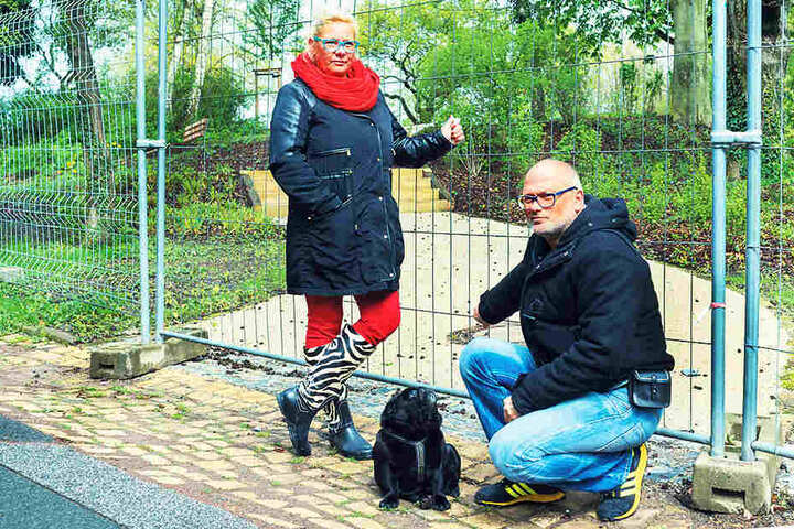 Ärgern sich über die lange Sperrung des Parks in Hellerau: Anwohner Lars (45)
und Yvonne Kühn (46) mit ihrem Mops Otto (6).