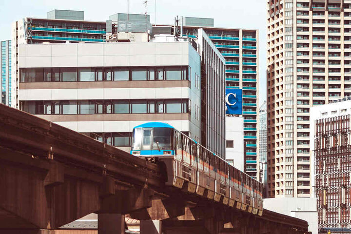 Eine Bahn fährt durch die Hochhausschluchten Tokios.