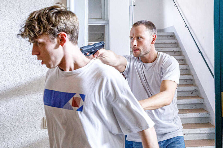 Der bewaffnete Geiselnehmer Max Riemelt (35, "Louis") drängt sein Opfer Emil Belton (20, "Nico") durch den Flur.