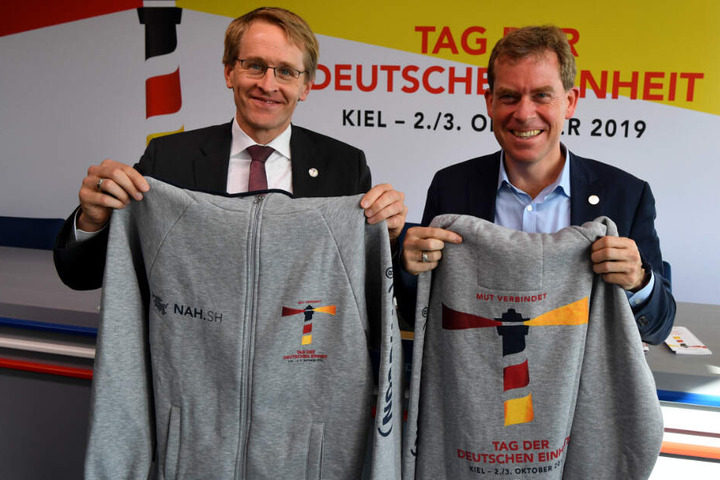 Freiwillige Helfer werden diese Jacken tragen, die Daniel Günther (CDU, links), Ministerpräsident von Schleswig-Holstein und Ulf Kämpfer (SPD), Kieler Oberbürgermeister, präsentieren.