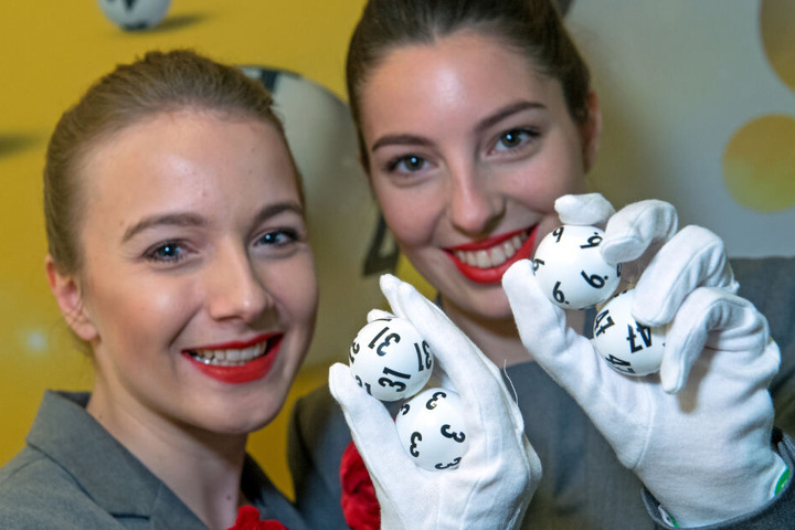 Die Sachsenlotto-Hostessen Lea Krebs (l.) und Franziska Henck halten die am häufigsten gezogenen Original-Lottozahlen in ihren Händen.