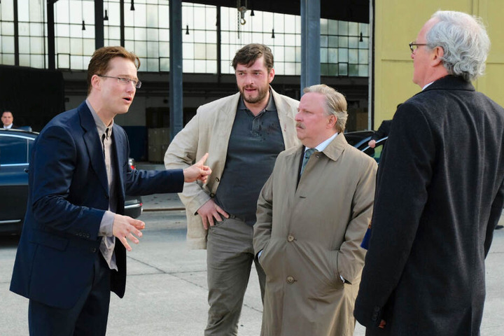 Martin Behrens (Zweiter von links; Ronald Zehrfeld) lauscht einer erregten Diskussion von Patrick Lemke (l., Alexander Fehling), Dr. Joachim Rauweiler (Axel Prahl) und Dr. Stefan Grünhagen (r., August Zirner).