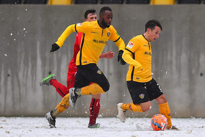 Dynamos Baris Atik (r.) führt den Ball auf dem schneebedecktem Geläuf und wird von Erich Berko (M.) überlaufen.