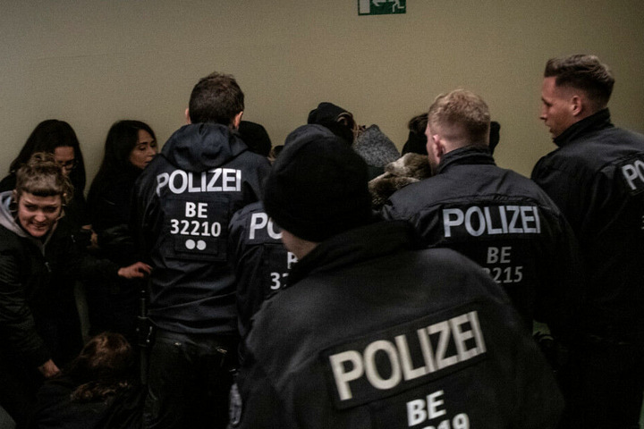 Demonstranten werden während des Prozesses in einem Flur des Landgerichtes am Tegeler Weg von Polizisten abgedrängt.