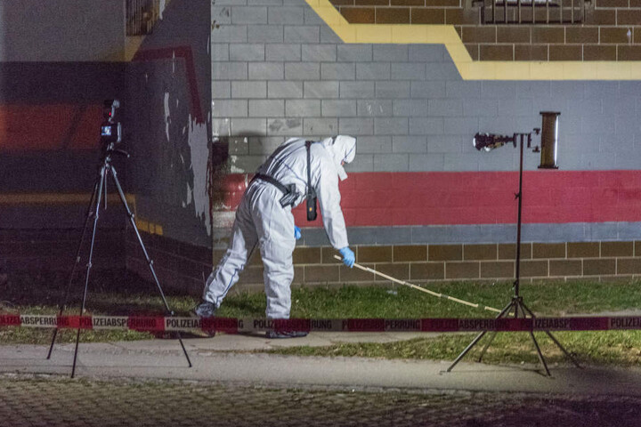 Ein Polizist sucht vor einem Haus in Weimar nach Spuren, die im Zusammenhang mit dem Verbrechen stehen könnten.