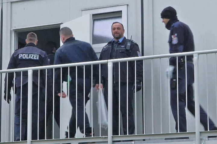 Polizeibeamte durchsuchen die Flüchtlingsunterkunft.