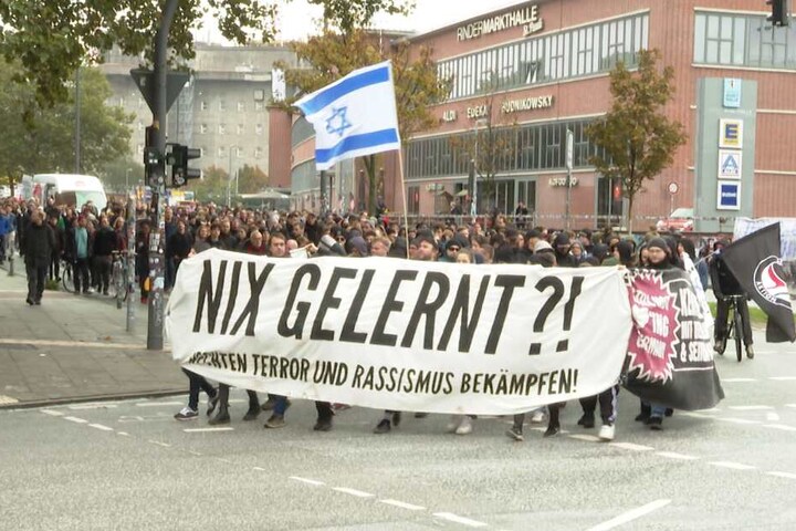 Mit Plakaten demonstrieren sie gegen rechten Terror.