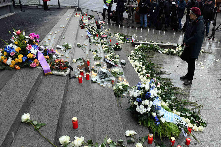 Passanten gedenken ein Jahr danach mit Blumen und Kerzen den Opfern.