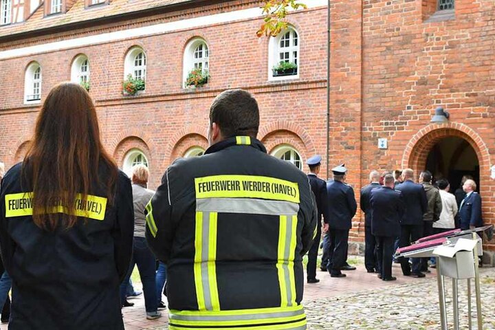 Zwei Feuerwehrleute aus Werder stehen vor dem Kloster Lehnin, wo die Trauernden sich versammelten.