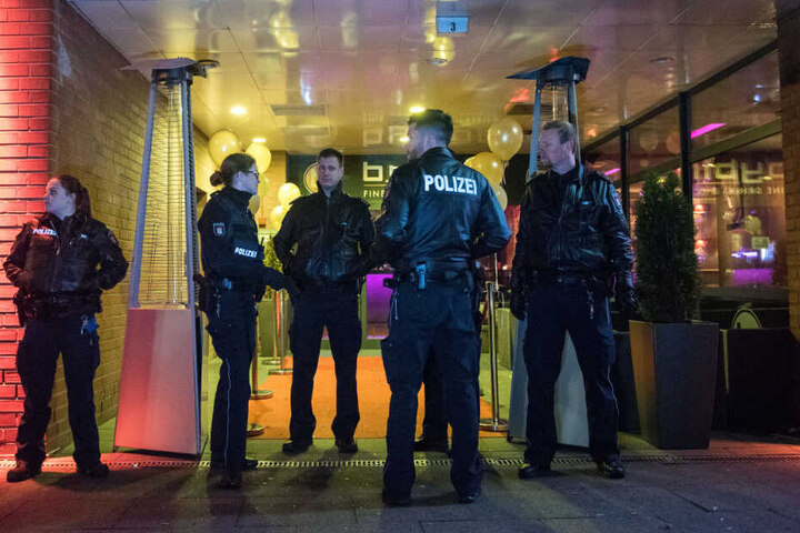Die Beamten stehen vor dem Eingang des Nachtclubs.