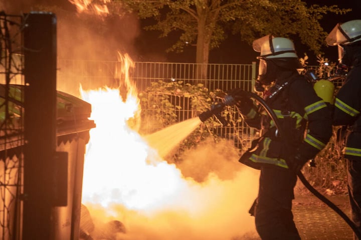 Obwohl die Müllcontainer stark brennen, bekommen die Einsatzkräfte das Feuer schnell in den Griff.