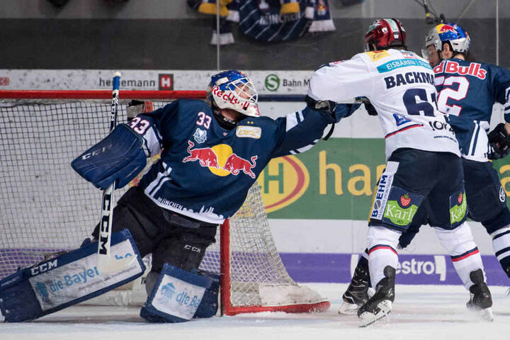 Sean Backman (r) von Berlin kämpft mit Torwart Danny Aus Den Birken von München um den Puck.