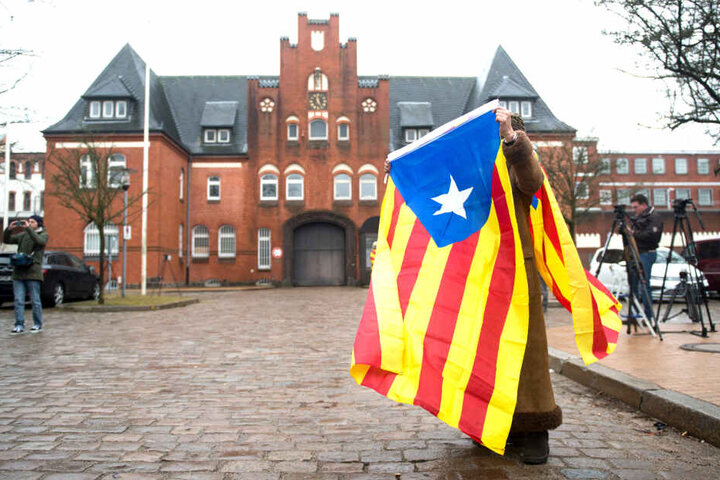 Eine Frau stand vor der JVA Neumünster in eine Estelada Blava, die Fahne der katalanischen Nationalisten. Der frühere katalanische Regionalpräsident Puigdemont befand zu der Zeit in Neumünster in Gewahrsam.