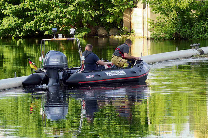 Feuerwehrleute suchen vom Boot aus die Uferzonen nach dem Vermissten ab.