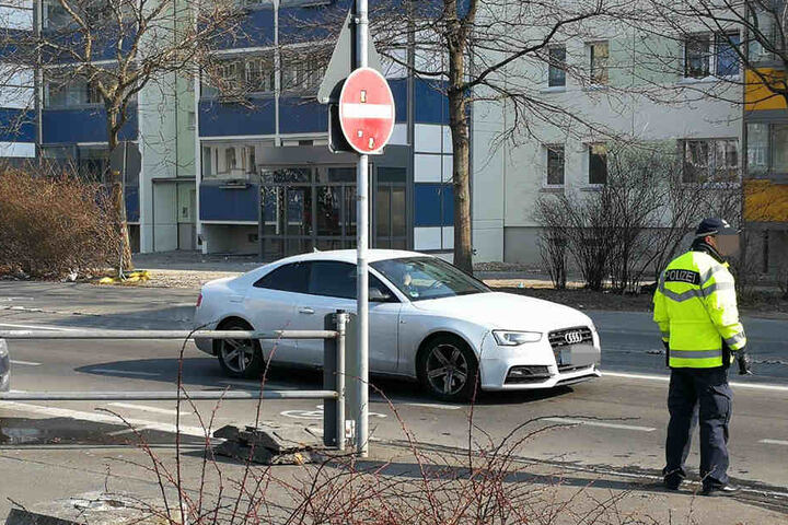 Ein Polizist warnt Auto- und Rollerfahrer vor dem Blitzeis durch den Wasserschaden.